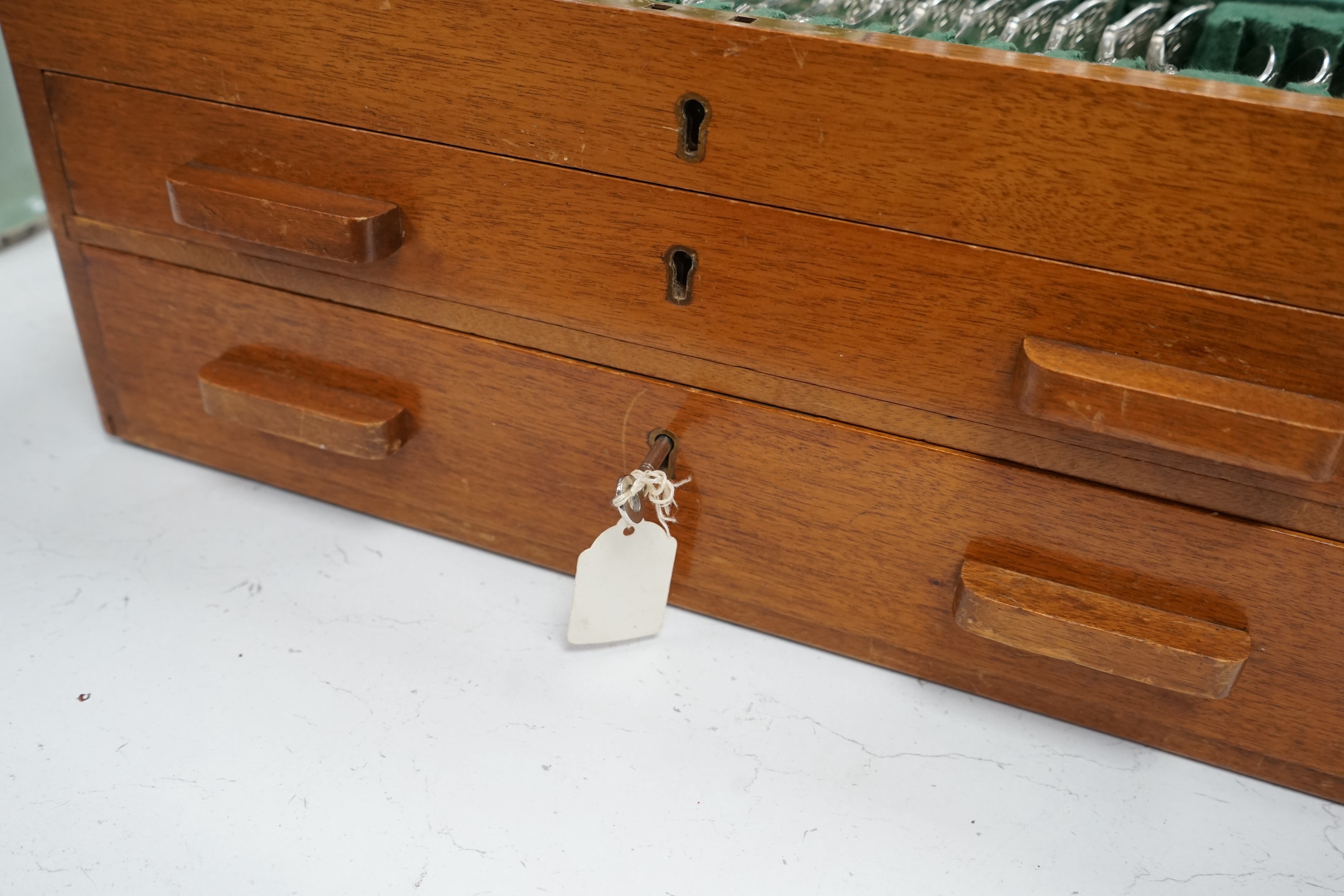 A mid 20th century canteen of Maple & Co silver plated King's pattern cutlery for twelve, comprising ninety six items, together with three odd pairs of plated sugar tongs, housed in a three drawer mahogany canteen with k